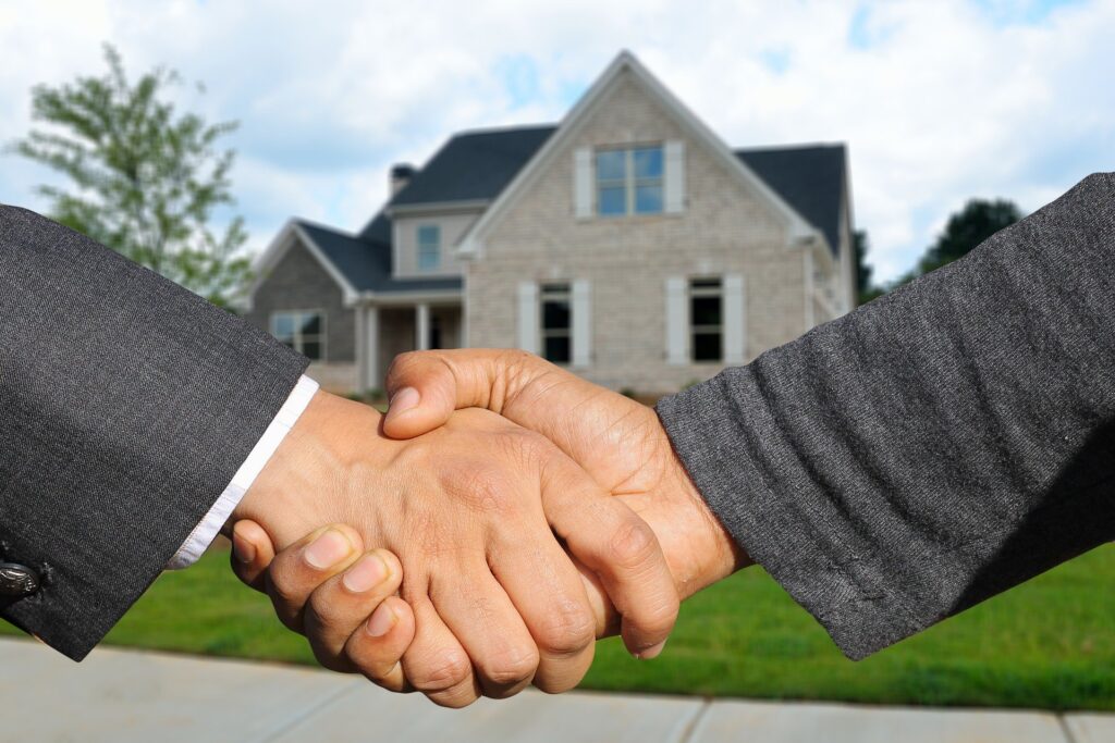 poignée de mains pour une maison en arrière plan